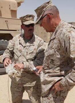 Commandant of the Marine Corps Gen. James Conway (right) speaks to Capt. James Shelstad, company commander for 1st Explosive Ordnance Disposal Company, 1st Marine Logistics Group (Forward), about the various improvised explosive devices used by insurgents against coalition forces. During the tour, Conway and Sergeant Major of the Marine Corps Carlton Kent were able to witness the various ways EOD techs counter the IED threat; one EOD tech demonstrated diffusing a notional IED buried under layers of dirt and rocks.