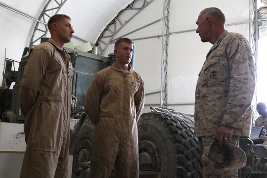 Commandant of the Marine Corps Gen. James Conway (right) speaks to Lance Cpl. Cody Clark (left) and Lance Cpl. Daniel Barten, intermediate maintenance mechanics with Combat Logistics Regiment 15 (Forward), 1st Marine Logistics Group (Forward), inside the repair warehouse at Camp Leatherneck, Afghanistan, Aug. 20. The CLR-15 (FWD) mechanics are able to repair a tactical vehicle severely damaged by an IED blast in under a month.