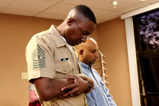 Master Gunnery Sgt. Hafiz N. A. Camp, enlisted manpower chief, Marine Corps Recruit Depot San Diego, prays before the feast during an iftar at Camp Pendleton’s South Mesa Chapel, Aug. 31. An iftar is a ritual for Muslims, enjoyed in a family or community setting that celebrates the Islamic holy period of Ramadan.