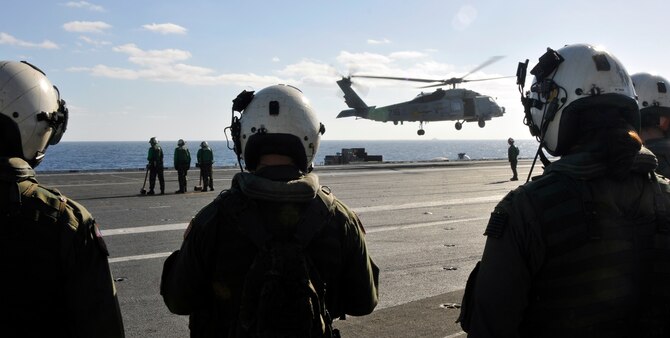 PACIFIC OCEAN - Pilots from the "Warlords" of Helicopter Anti-Submarine Squadron Light (HSL) 51 wait for an SH-60B Seahawk to land on the flight deck aboard USS George Washington (CVN 73), Dec. 4. The GW is currently participating in Keen Sword 2010 with the Japanese Self Defense Forces. This exercise enhances the Japan-U.S. alliance which remains a key strategic relationship in the Northeast Asia Pacific region. Keen Sword caps the 50th anniversary of the Japan-U.S. alliance as an "alliance of equals." The exercise runs through Dec. 10. (U.S. Navy photo by Mass Communication Specialist 3rd Class David A. Cox)