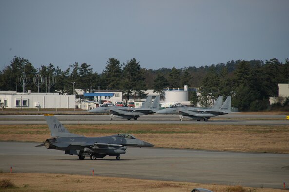 An F-16 Fighting Falcon from Misawa Air Base, Japan, moves across the runway as two Japanese F-15s prepare for take-off at Komatsu Japanese Air Self Defense Force Base, Japan, Dec. 7. Airmen from the U.S. and Japan are currently operating out of the base as part of exercise Keen Sword 2011. Dubbed the largest exercise ever between the two nations, Keen Sword involves all components of U.S. Joint Forces and Japanese Self-Defense Forces training to conduct bilateral operations in support of the defense of Japan in a number of locations throughout the country.
