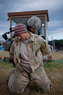Senior Airman Kevin Gonzales, 35th Security Forces Squadron patrolman searches Senior Airman William Holliday, 35th Explosive Ordnance Disposal and opposing forces member, Dec. 4, 2010, during a bilateral guard and protect exercise at Misawa Air Base, Japan.  Opposing forces simulated hostile enemy actions against Japan Ground Self Defense Force and Air Self Defense Force and the 35th SFS during the exercise to test the combined force’s ability to protect Misawa’s war fighting assets.  (U.S. Air Force photo by Senior Airman Jessica Lockoski) 