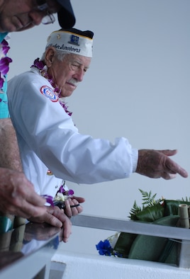 Delton "Wally" Walling, a survivor of the Dec. 7, 1941, Japanese attack on Pearl Harbor, throws flowers overboard the USS Arizona Memorial during the 69th anniversary commemoration Dec. 7, 2010. (U.S. Air Force photo/Staff Sgt. Carolyn Viss)
