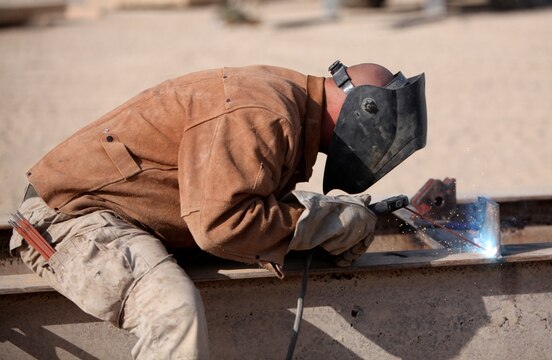 Sgt. Kenneth Cole, welder chief, Maintenance Platoon, Support Company, 8th Engineer Support Battalion, 1st Marine Logistics Group (Forward), welds pieces of steel together during the fabrication of a bridge at Camp Leatherneck, Afghanistan, Dec. 21. The 8th ESB Marines built the bridge out of steel and wood, which will serve as a permanent replacement for a medium girder bridge in Marjah.