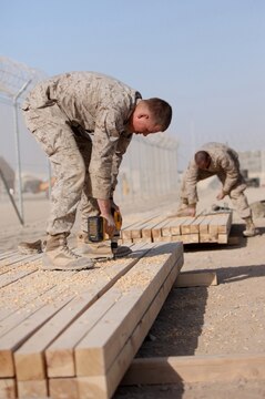 Marines with 8th Engineer Support Battalion, 1st Marine Logistics Group (Forward), drill holes into wooden planks as they build a bridge at Camp Leatherneck, Afghanistan, Dec. 21. The 8th ESB Marines built the bridge out of steel and wood, which will serve as a permanent replacement for a medium girder bridge in Marjah.