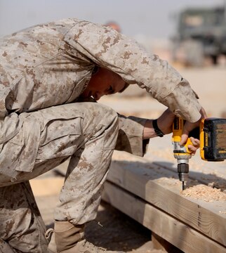 Marines with 8th Engineer Support Battalion, 1st Marine Logistics Group (Forward), drill holes into wooden planks as they build a bridge at Camp Leatherneck, Afghanistan, Dec. 21. The 8th ESB Marines built the bridge out of steel and wood, which will serve as a permanent replacement for a medium girder bridge in Marjah.