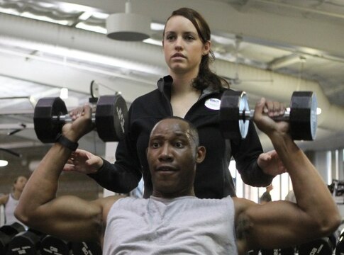 Annaleis Petrich, personal trainer, Semper Fit Division, Marine Corps Community Services, ensures Staff Sgt. Rhashad E. Morton, Combat Logistics Regiment 1, 1st Marine Logistics Group, is using the correct technique during a shoulder press at the Paige Fieldhouse fitness center, Feb. 11. Personal trainers are free to anyone with gym access, and they provide health and fitness advice. The trainers also work hand-in-hand with the Wounded Warrior Battalion and Naval Hospital Camp Pendleton to support the Return-to-Readiness program for injured warriors.