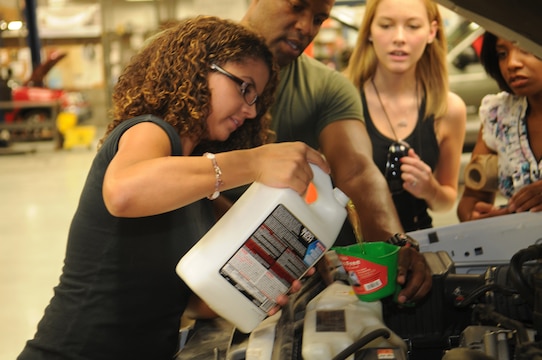 Doorly Winegar, Marine Attack Squadron 211 spouse, pours antifreeze into a vehicle during a vehicle maintenance class in the auto hobby shop at the Marine Corps Air Station in Yuma, Ariz., July 16, 2010. The class is the first of several educational blocks designed to help squadron spouses become more self-sufficient when their Marines are deployed overseas. “I feel more empowered to take care of myself,” said Winegar. “I definitely recommend it.”