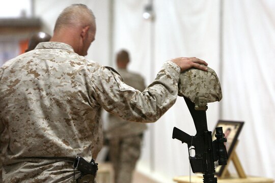 A Marine pays his final respects to Gunnery Sgt. Christopher Eastman, an explosive ordnance disposal technician with 1st EOD Company, 7th Engineer Support Battalion, 1st Marine Logistics Group (Forward) who died July 18 while supporting combat operations in Helmand Province, during a memorial service at Camp Leatherneck, Afghanistan, July 25. Eastman, 28, from Moose Pass, AK, enlisted in the Marine Corps in 1999 as a combat engineer. He lateral moved into EOD in 2006 and deployed to Iraq in 2008. He is survived by his wife, Rocio, and daughter, Joy.