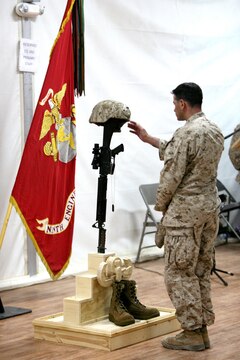 A Marine pays his final respects to Gunnery Sgt. Christopher Eastman, an explosive ordnance disposal technician with 1st EOD Company, 7th Engineer Support Battalion, 1st Marine Logistics Group (Forward) who died July 18 while supporting combat operations in Helmand Province, during a memorial service at Camp Leatherneck, Afghanistan, July 25. Eastman, 28, from Moose Pass, AK, enlisted in the Marine Corps in 1999 as a combat engineer. He lateral moved into EOD in 2006 and deployed to Iraq in 2008. He is survived by his wife, Rocio, and daughter, Joy.