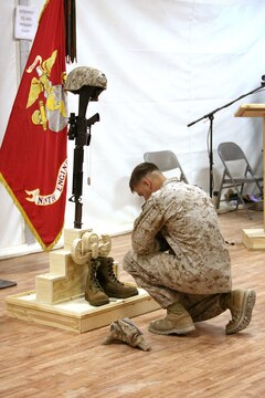 A Marine pays his final respects to Gunnery Sgt. Christopher Eastman, an explosive ordnance disposal technician with 1st EOD Company, 7th Engineer Support Battalion, 1st Marine Logistics Group (Forward) who died July 18 while supporting combat operations in Helmand Province, during a memorial service at Camp Leatherneck, Afghanistan, July 25. Eastman, 28, from Moose Pass, AK, enlisted in the Marine Corps in 1999 as a combat engineer. He lateral moved into EOD in 2006 and deployed to Iraq in 2008. He is survived by his wife, Rocio, and daughter, Joy.