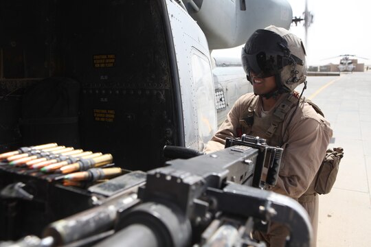 Cpl. Estanislao Alvarez, a UH-1Y Huey crew chief with Marine Light Attack Helicopter Squadron 369, 3rd Marine Aircraft Wing (Forward), checks his gun before responding to a call for help from a small Danish ground unit July 25.  Alvarez was wounded about two months ago conducting an emergency resupply mission for special operations Marines. Alvarez was offered a chance to leave Afghanistan after he was wounded, but refused.  Instead, he chose to remain with his unit and fellow Marines for the duration of HMLA-369's deployment.