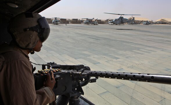 Cpl. Estanislao Alvarez, a UH-1Y Huey crew chief with Marine Light Attack Helicopter Squadron 369, 3rd Marine Aircraft Wing (Forward),  crews the left-side door gun of a Huey while launching from the flight line here to respond to a call for help from a small Danish ground unit, July 25.  Alvarez was wounded about two months ago conducting an emergency resupply mission for special operations Marines. Alvarez was offered a chance to leave Afghanistan after he was wounded, but refused.  Instead, he chose to remain with his unit and fellow Marines for the duration of HMLA-369's deployment.