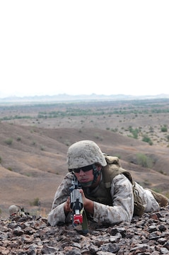 Cpl. Ricardo Montanez, Marine Air Control Squadron 1 navigational aid technician, provides security while his squad moves forward during a corporals course July 27, 2010, at the Marine Corps Air Station in Yuma, Ariz. The squad’s movements lead it to a simulated terrorist outpost which the squad then had to attack. The attack was the culmination exercise for the course focusing on small-unit combat leadership instead of drill and tradition.