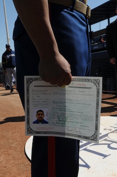 Cpl. Jorge Martinez, Marine Attack Squadron 214 airframer, stands with his certificate of citizenship at the Peoria Sports Complex in Peoria, Ariz., March 10, 2010. Both he and Cpl. Marvin Medeiros, Headquarters and Headquarters Squadron food service specialist, received their certificates during a ceremony before a San Diego Padres and Milwaukie Brewers game. Martinez and his family immigrated to the U.S. from Mexico in 1986, while Medeiros emigrated from Peru in 2000. Both Marines are based at the Marine Corps Air Station in Yuma, Ariz.