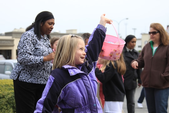 Lauren Miller, 7, proudly shows the eggs she collected to her mother after the 2010 annual Easter Egg hunt at the commissary here March 26. Miller participated in the second hunt for ages 6-10, where she found several eggs including a shiny-golden prize egg.