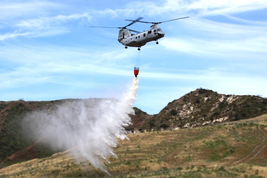 A CH-46 Sea Knight helicopter from 3rd Marine Air Wing, Marine Corps Air Station Miramar, empties more than 320 gallons water from the nearby Las Pulgas Lake during the third annual aerial firefighting effort at Camp Pendleton, May 13. Approximately 34 emergency service personnel and several aircraft from Marine Corps Base Camp Pendleton, Marine Corps Air Station Miramar, Naval Air Station North Island and California’s Department of Fire and Forestry Protection (CAL FIRE) extinguished simulated fires on base by coordinating helicopter water drops.