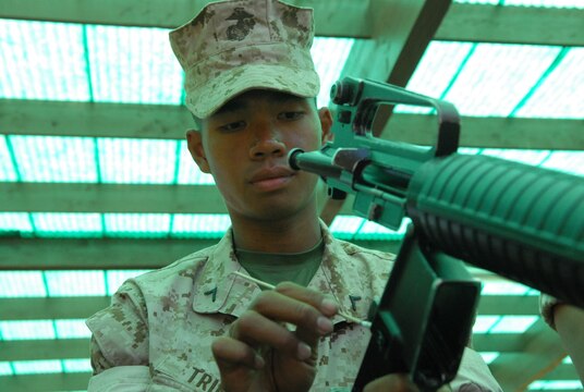 Private First Class Duy Trinh cleans his rifle for the last time before turning it in to the depot armory.