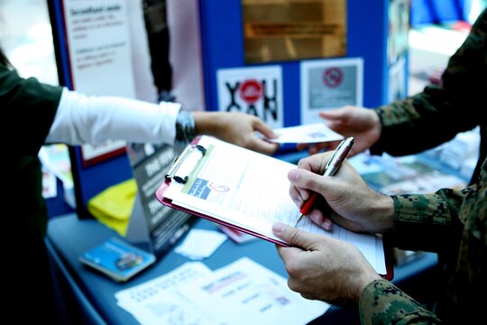 A service member signs a pledge to quit smoking for a duration of at least 24 hours at a nicotine awareness and tobacco cessation booth during the Great American Smokeout at the Marine Corps Exchange aboard Marine Corps Base Camp Lejeune, Nov. 18. The Smokeout is an annual event held on the third Thursday of November in locations across the nation, raising nicotine awareness and encouraging millions of Americans to stop smoking.