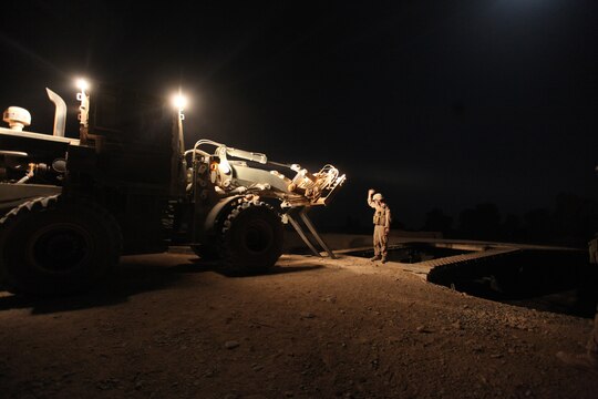 Cpl. Kevin S. Major, heavy equipment noncommisioned officer with Bridge Platoon, Company A, 9th Engineer Support Battalion, 1st Marine Logistics Group (Forward), guides a bulldozer during a bridge replacement project in Marjah, Afghanistan, oct. 23. The Marines removed an old medium girder bridge and replaced it with a newer medium girder bridge, to be used by coalition forces and local nationals.