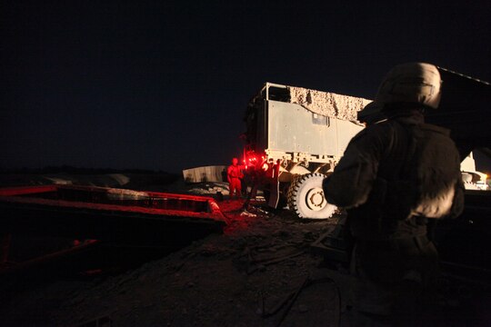 Marines with Bridge Platoon, Company A, 9th Engineer Support Battalion, 1st Marine Logistics Group (Forward), pull a double story medium girder bridge with a 7-ton truck during a bridge replacement project in Marjah, Afghanistan, Oct. 23. The Marines removed an old medium girder bridge and replaced it with a newer one, to be used by coalition forces and local nationals.