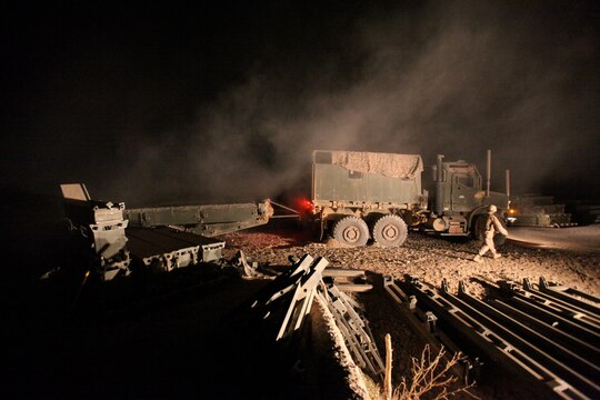 Marines with Bridge Platoon, Company A, 9th Engineer Support Battalion, 1st Marine Logistics Group (Forward), pull a double story medium girder bridge with a 7-ton truck during a bridge replacement project in Marjah, Afghanistan, Oct. 23. The Marines removed an old medium girder bridge and replaced it with a newer one, to be used by coalition forces and local nationals.
