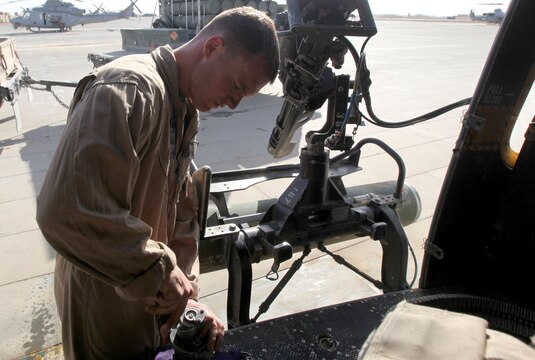 Cpl. Ryan Smith, a UH-1Y Huey crew chief with Marine Light Attack Helicopter Squadron 369, 3rd Marine Aircraft Wing (Forward), puts a de-linker back together on an M134 Minigun. The Huey is being prepped as the troops in contact, or TIC, response aircraft.  HMLA-369 responds to TIC requests when coalition forces call for immediate aerial support.