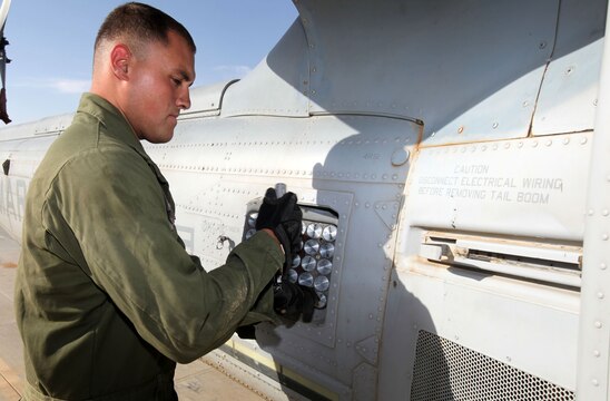 Cpl. Luis Dunn, an aviation ordnance technician with Marine Light Attack Helicopter Squadron 369, 3rd Marine Aircraft Wing (Forward), secures a flare box to the side of a UH-1Y Huey.  The Huey is being prepared as the troops in contact, or TIC, response aircraft.  HMLA-369 responds to TIC requests when coalition forces call for immediate aerial support.