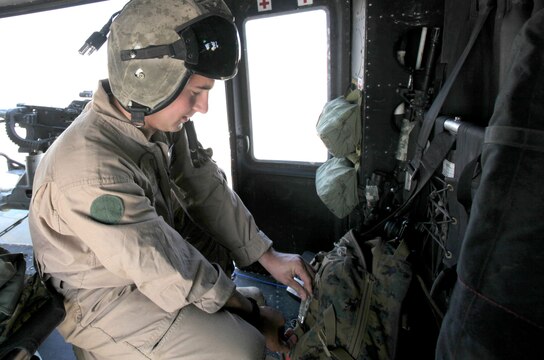 Sgt. Carson Ferraro, a UH-1Y Huey crew chief with Marine Light Attack Helicopter Squadron 369, 3rd Marine Aircraft Wing (Forward), prepares his gear on the troops in contact, or TIC, response Huey. Marines ensure the aircraft is prepared for a quick start-up and takeoff in case the squadron is called on to support ground troops. One Huey and one AH-1W Cobra are always on call to fill the position of TIC response aircraft.