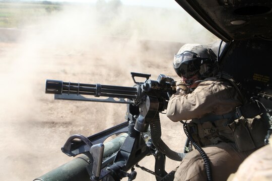 A UH-1Y crew chief with Marine Light Attack Helicopter Squadron 369, 3rd Marine Aircraft Wing (forward) mans the GAU-17/A 7.62mm machine gun while gathering key coalition personnel to be inserted into the Ismaat Bazaar in Helmand province, Afghanistan Sept. 27.  The insert was in support of operation Oasis, which established coalition presence in a suspected insurgent logistic hub.