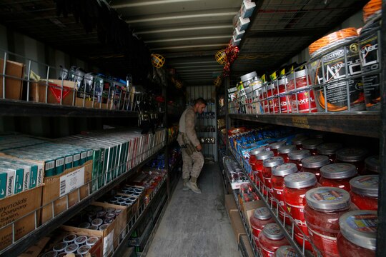 Warfighter Express Services Team staff noncommissioned officer, Staff Sgt. Erick Landers, Marine Corps Community Services, 2nd Marine Logistics Group (Forward), takes inventory of items in the mobile exchange trailer, April 29, 2011, aboard Combat Outpost Cafferetta, Afghanistan.