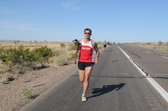 Gunnery Sgt. Scott Hubbard, criminal investigations division chief investigator, runs with a torch as part of the Law Enforcement Torch Run for the Special Olympics along a barren, open desert section of Interstate 8, April 28, 2011. Marines from the provost marshal’s office took part in the annual event, running 15 miles to raise money for the Special Olympics.