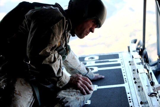 Staff Sgt. James D. Nine, the platoon sergeant of Air Delivery Platoon, Landing Support Company, Combat Logistics Regiment 17, 1st Marine Logistics Group, watches for landmarks telling him how close he is to the landing zone, flying above Camp Pendleton, Calif., Aug. 23. Air Delivery Platoon conducted a personnel jump over the hills of the base. The primary purpose of the jump was to get jump masters qualified for operations.