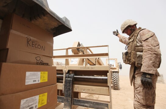 Lance Cpl. Robert Dearborn, a motor transportation operator with Combat Logistics Battalion 6, 2nd Marine Logistics Group (Forward), guides a fork truck into place as Marines unloaded dozens of boxes of fresh and frozen foods at Patrol Base Alcatraz, Aug, 26. (U.S. Marine Corps photo by Sgt. Justin J. Shemanski)