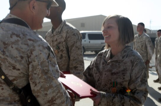 Lance Cpl. Caitlin E. Johnson, a native of Creswell, Ore., receives a Navy and Marine Corps Achievement Medal from Brig. Gen. Michael G. Dana, the commanding general for 2nd Marine Logistics Group (Forward), during a ceremony aboard Camp Leatherneck, Afghanistan, Dec. 30. Johnson demonstrated remarkable leadership qualities during the holiday mail rush. During this time she assisted her contemporaries with processing more than 3 million pounds of mail, while displaying a tireless work-ethic and morale-building spirit. (U.S. Marine Corps photo by Sgt. Justin J. Shemanski)