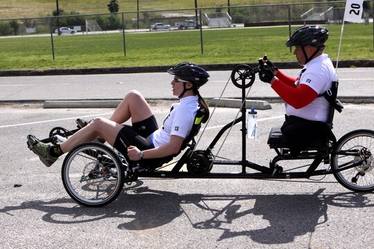 Chuck Sketch, a swimmer, shooter and cyclist for the Veterans Team, rides a two-passenger bike with Maj. Susan Stark, the event director, during one of the Camp Pendleton 2011 Marine Corps Trials 10 kilometer cycling competitions, Feb. 23. Stark acts as Sketch's eyes as he uses the hand cranks to power the duo. Sketch, a native of Wildomar, Calif., lost his sight from brain cancer in 1997 and lost both of his legs due to complications with blood clots in 1998.
