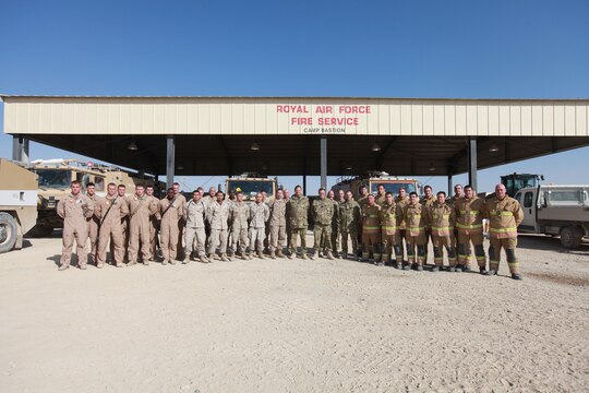 U.K. firefighters and Marines from the Aircraft Rescue and Firefighting section of Marine Wing Support Squadron 373, 3rd Marine Aircraft Wing (Forward), receive letters of appreciation from U.K. Royal Air Force Group Captain Guy van den Berg, the commanding officer of the 903rd Expeditionary Air Wing and airfield manager, for their superior service while working in a joint environment aboard Camp Bastion, Afghanistan, Jan. 25.