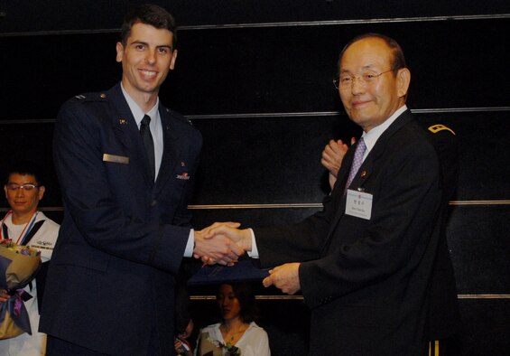 SEOUL, Republic of Korea -- Chul Soo Han, Korea America Friendship Society chairman, gives Capt. (Dr.) David Schindler, 8th Medical Operations Squadron general dentist and infection control officer, with the Korea America Friendship Society Award 2011 at the 20th Annual Korea America Friendship Night here June 30. (U.S. Air Force photo/Senior Airman Benjamin Stratton)