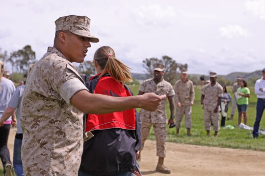 Staff Sgt. Isaac D. Diaz, data chief with Combat Logistics Regiment 1, 1st Marine Logistics Group, and a former drill instructor motivates family members of Marines and sailors at the annual John/Jane Wayne Day held at Camp Pendleton, March 19. The family members were welcomed to John/Jane Wayne Day and given the opportunity to see what their Marines do on a daily basis. Events included a Combat Fitness Test, rifle and pistol shooting, a Marine Corps Martial Arts Program lesson, an Explosive Ordnance Disposal display, and a military working dog demonstration.