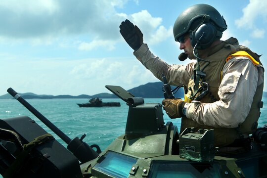 1st Lt. Nishan Campbell, AAV platoon commander, Landing Force CARAT, signals other Amphibious Assault Vehicles May 17 during a rehearsal for the final training exercise (FTX) in Thailand during Cooperation Afloat Readiness and Training 2011. CARAT is an annual bilateral exercise held between the U.S. and Southeast Asia nations with the goals of enhancing regional cooperation, promoting mutual trust and understanding, and increasing operational readiness. U.S. and Thai militaries are using AAVs, Marines and Sailors for the beach assault on May 18. The majority of the U.S. Marines participating in CARAT are reserve Marines who volunteered for the training. The U.S. Marine Corps Reserve is an integral element of the Marine Corps Operating Forces and shares the expeditionary mindset that encompasses the Marines’ culture.