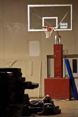 U.S. Air Force Tech. Sgt. David Perez, convoy commander, 70th medium truck detachment and Santa Fe, NM., native sleeps on the floor of the gym at Forward Operating Base Warrior Oct. 28, 2011.  As bases begin to shrink and personnel support services shut down, the trucker crews become more creative on finding places to sleep. The team is taking 43 vehicles and 60 passengers more than 1,100 miles through Iraq to transport equipment and supplies out of the country in order to meet the military transition deadline. (U.S. Air Force Photo/Master Sgt. Jeffrey Allen)