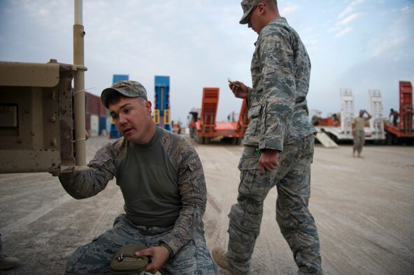 U.S. Air Force Staff Sgt. Brandon Dejarnette (left) and Senior Airman Micah Olson, vehicle operators assigned to the 70th medium truck detachment, record shipping information on a mine-resistant ambush protected vehicle before it is loaded in a trailer at forward Operating Base Warrior on Oct. 29, 2011. After driving all night while in a 43 vehicle convoy 150 miles through Iraq, Airmen from the 70th MDS have to complete loading their trucks before getting to sleep. (U.S. Air Force Photo/Master Sgt. Jeffrey Allen)