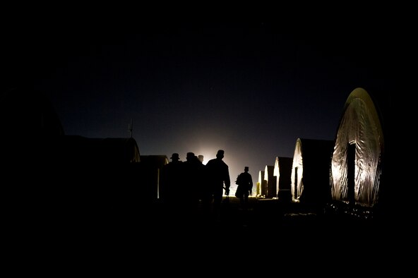 U.S. Air Force Airmen assigned to the  70th medium truck detachment, walk to their tent after completing the first leg of a seven day convoy on Oct. 23, 2011. The convoy of 43 vehicles and 60 passengers will travel more than 1,100 miles to assist with the transport of equipment and supplies from Iraq. (U.S. Air Force Photo/Master Sgt. Jeffrey Allen)