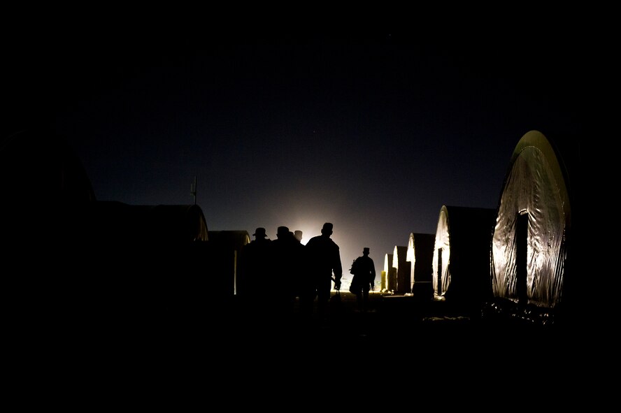 U.S. Air Force Airmen assigned to the  70th medium truck detachment, walk to their tent after completing the first leg of a seven day convoy on Oct. 23, 2011. The convoy of 43 vehicles and 60 passengers will travel more than 1,100 miles to assist with the transport of equipment and supplies from Iraq. (U.S. Air Force Photo/Master Sgt. Jeffrey Allen)