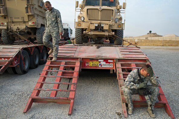 U.S. Air Force Staff Sgt. William Clarkson (right) an Auburn, Calif. native, and Senior Airman Micah Olson, 70th medium truck detachment, finished loading mine-resistant ambush protected vehicles onto contracted trucks at Forward Operating Base Warrior, Iraq on Oct. 27, 2011. Clarkson and Olson drove all night in a convoy to get to FOB Warrior before loading the trucks and are scheduled to depart later in the evening. The convoy of 43 vehicles and 60 passengers traveled more than 1,100 miles through Iraq. (U.S. Air Force Photo/Master Sgt. Jeffrey Allen)