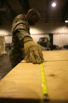 Sgt. Paul Evans, Marine Forces Europe Embarkation chief, measures the length of disaster relief gear at the Vaernes International Airport in Norway, Nov. 14. With assistance from Norwegian soldiers with the Marine Corps Prepositioning Program in Norway, the pallets would later be filled with 110 cold weather tents, space heaters and fuel cans to be flown to Erzurum, Turkey, via C-130, to help provide shelter and warmth to more than 1,000 Turkish citizens left homeless by recent earthquakes. “It is crucial that all the gear is loaded properly, and done so the first time,” said Evans, who resides from Bakersfield, Calif. “We don't want to overload the aircraft, or load it unbalanced, otherwise it will either leave late, or even worse, gear would have to be left behind.”::r::::n::::r::::n::::r::::n::