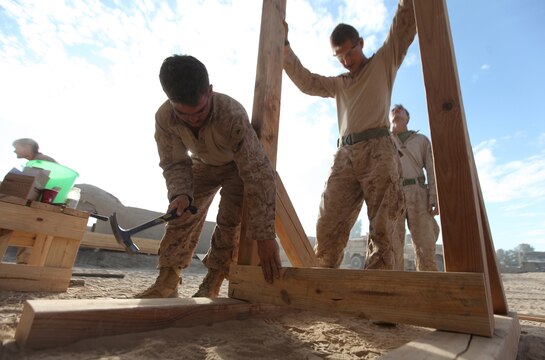 Sgt. Paul Geren (right), of Battle Creek, Mich., and Lance Cpl. Michael Stout (left), of Fremont, Mich., finalize construction of a pull-up bar at Patrol Base New Jersey, Afghanistan, November 23. Geren, a combat engineer, and Stout, a motor transportation mechanic, are members of Combat Logistics Company 6, 2nd Marine Logistics Group (Forward). The CLC, which is comprised of two engineer platoons and one motor transportation platoon, is an element of Combat Logistics Battalion 6 and was formed to provide direct support to 1st Battalion, 6th Marine Regiment, during Operation Eastern Storm. Engineers were tasked with building several of the patrol bases along Route 611. Once force protection measures were in place, such berms and concertina, the Marines then built comfort items that included benches, hygiene facilities and gym equipment for the infantrymen operating from the bases. (U.S. Marine Corps photo by Sgt. Justin J. Shemanski)