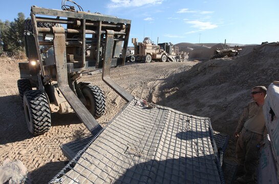 Lance Cpl. Scott Steffens (right), of Traverse City, Mich., guides a fork truck operated by Lance Cpl. Ryan Anderson, of Applegate, Ore., into place at Patrol Base New Jersey, Afghanistan, Nov. 23. Both Marines are heavy equipment operators with Combat Logistics Company 6, 2nd Marine Logistics Group (Forward). The CLC, which is comprised of two engineer platoons and one motor transportation platoon, is an element of Combat Logistics Battalion 6 and was formed to provide direct support to 1st Battalion, 6th Marine Regiment, during Operation Eastern Storm. Engineers were tasked with building several of the patrol bases along Route 611. (U.S. Marine Corps photo by Sgt. Justin J. Shemanski)