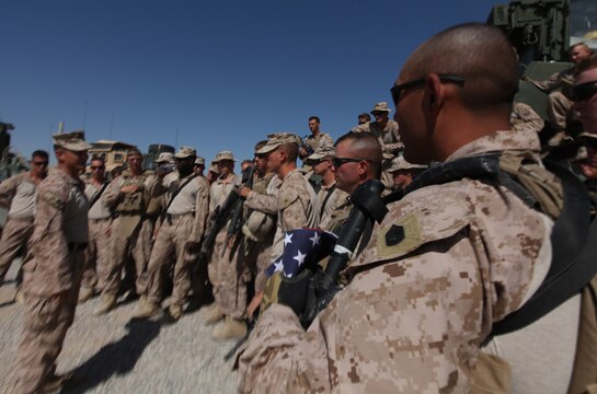 Gunnery Sgt. Ricardo Ojeda, a platoon sergeant with Combat Logistics Company, Combat Logistics Battalion 6, clutches an American flag as his platoon is briefed prior to departing Forward Operating Base Nolay, Afghanistan, Oct. 16. The CLC provides direct service support to the 1st Battalion, 6th Marine Regiment. (U.S. Marine Corps photo by Sgt. Justin J. Shemanski)
