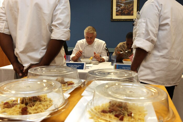 Mark Allison, the dean of culinary arts at the Charlotte campus for Johnson and Wales University, judges the meals made by a team of civilian chefs during the third quarter Culinary Team of the Quarter competition at Mess Hall 411 abaord Marine Corps Base Camp Lejeune, Oct. 18.